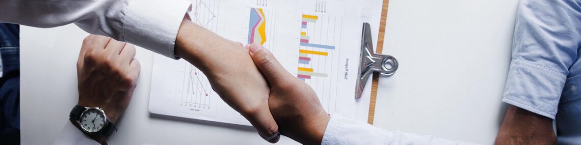 Business people shaking hands to close an M&A deal