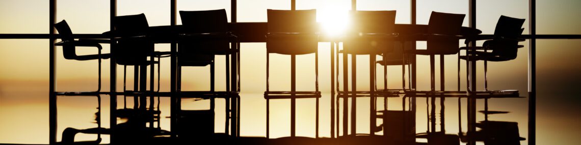 Corporate board of directors meeting room empty with sunlight coming through windows