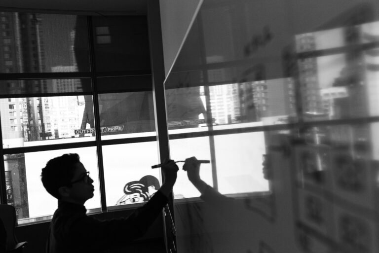 Black and white photo of founder writing business plans on whiteboard