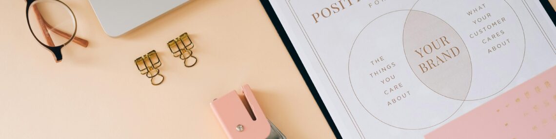 Brand position strategy documents on desk with laptop