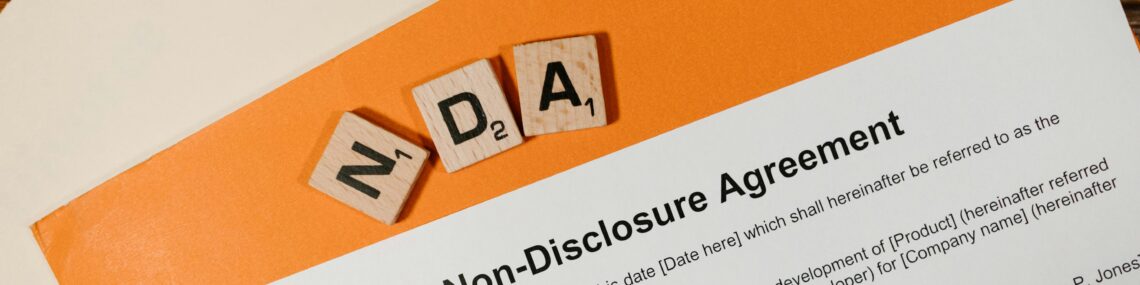 Non Disclosure Agreement paperwork on desk with NDA letter blocks confidentiality agreement