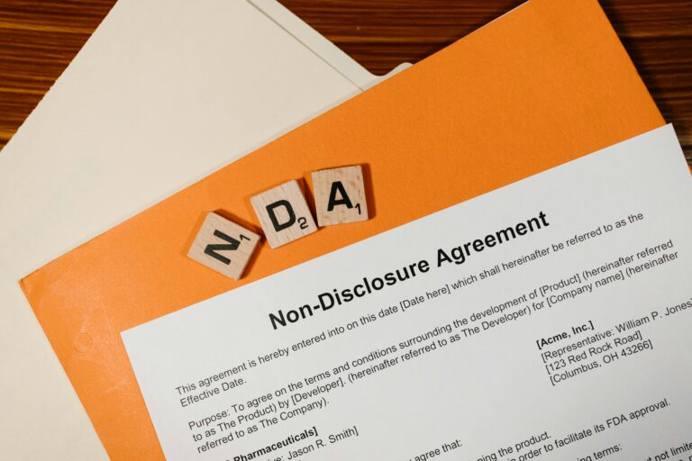 Non Disclosure Agreement paperwork on desk with NDA letter blocks confidentiality agreement