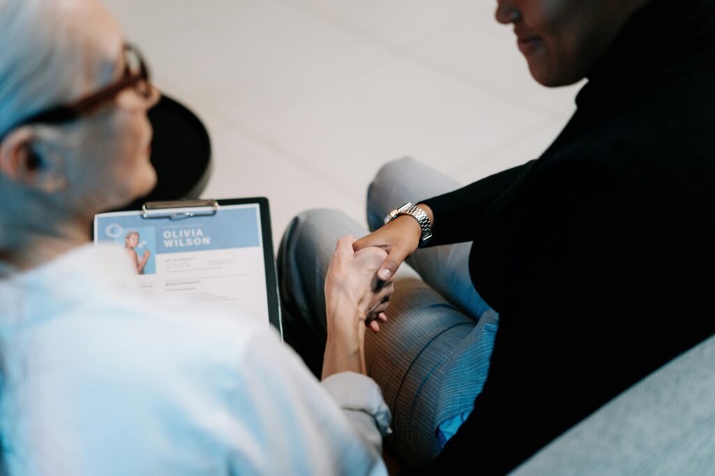 woman shaking hands after being offered a job during an interview