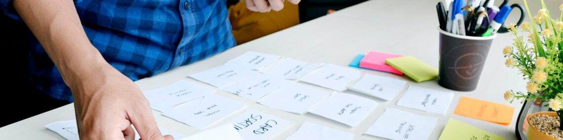 business founder setting out sticky notes and cards while forming a business plan