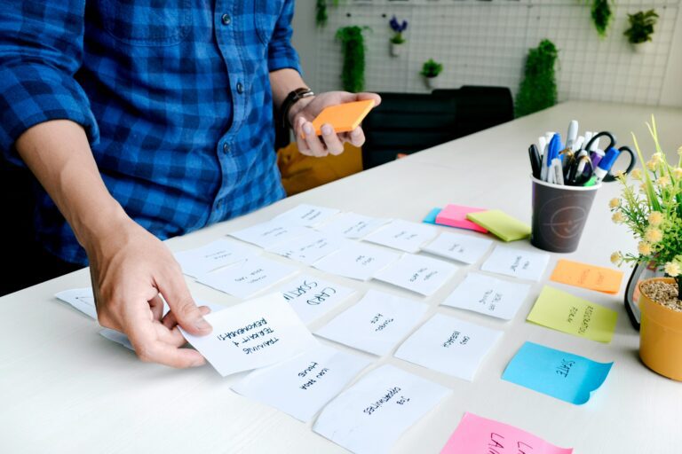 business founder setting out sticky notes and cards while forming a business plan