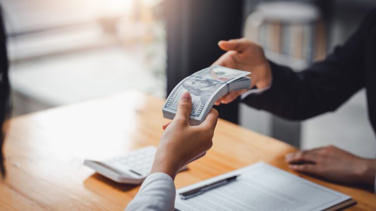 Business people exchanging cash for sale of business. Mergers and acquisitions.
