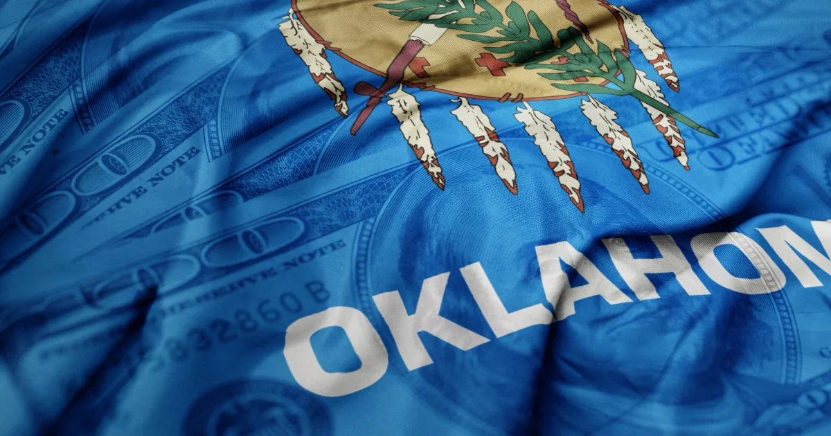 Oklahoma state flag laid over US currency