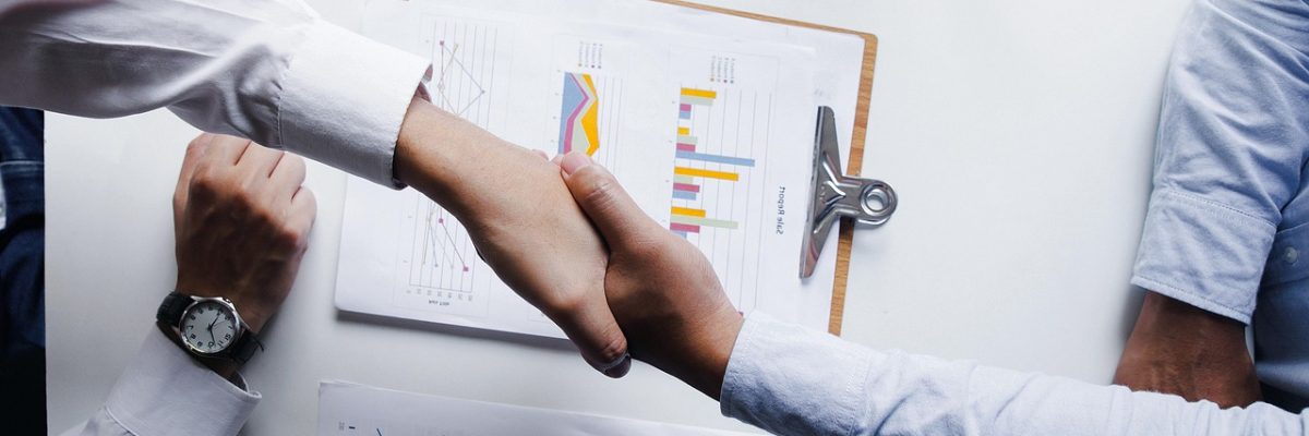 Business people shaking hands to close an M&A deal