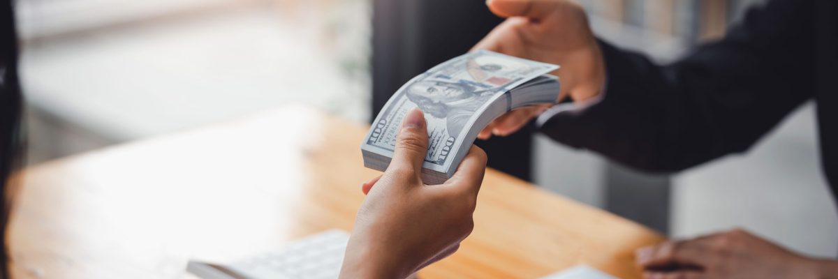 Business people exchanging cash for sale of business. Mergers and acquisitions.