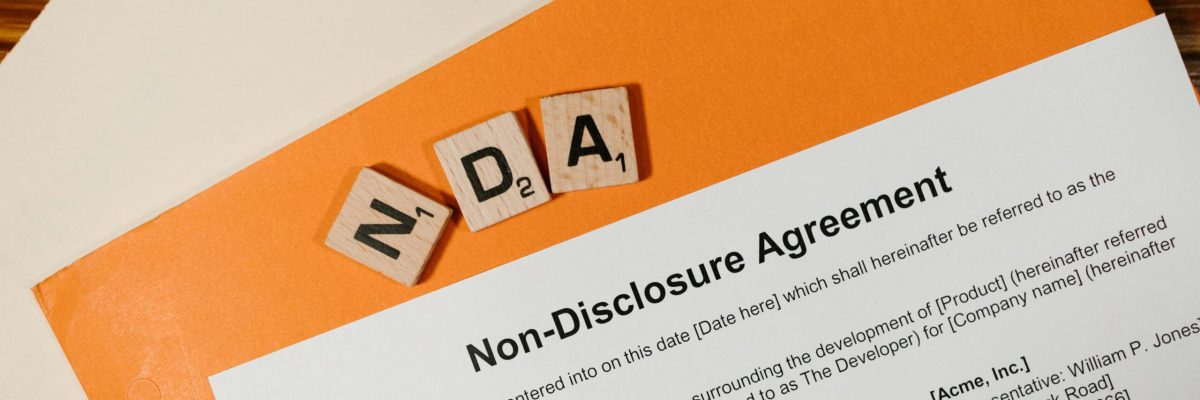 Non Disclosure Agreement paperwork on desk with NDA letter blocks confidentiality agreement