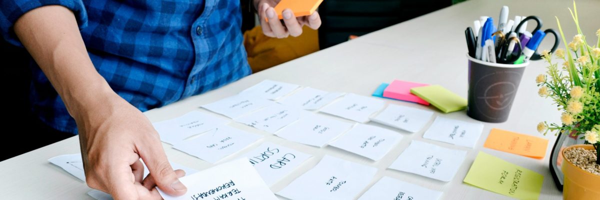business founder setting out sticky notes and cards while forming a business plan